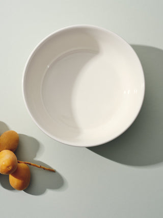 White bowl next branch of pears