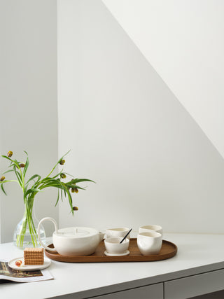 Complete large tea set on a desk next to a vase of flowers