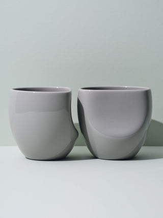 Two grey assymmetrical cups lined next to each other