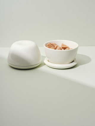 Two lidded ceramic bowls, one closed, one open revealed candied ginger