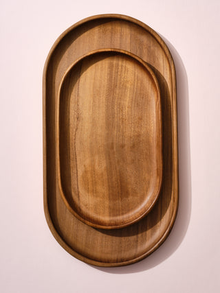 A small wooden tray on top of a medium wooden tray