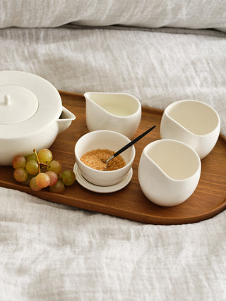 Complete large tea set on linen bed sheets  